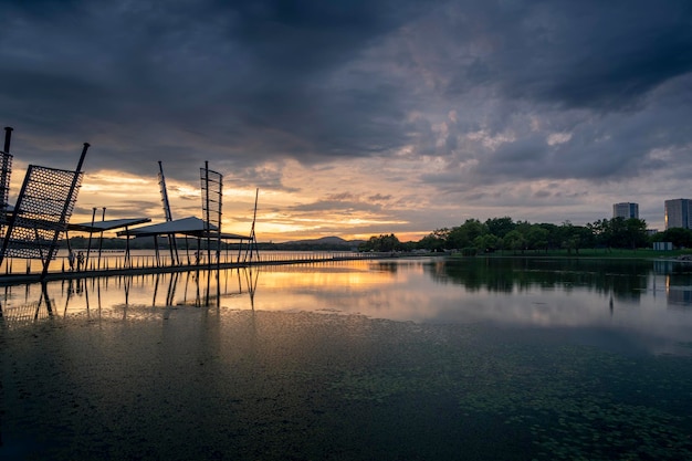 Beautiful long bridge over the lake in the city at sunset