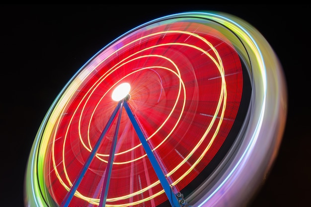 Beautiful Long exposure picture of a ferris wheel rotating, vivid colors.