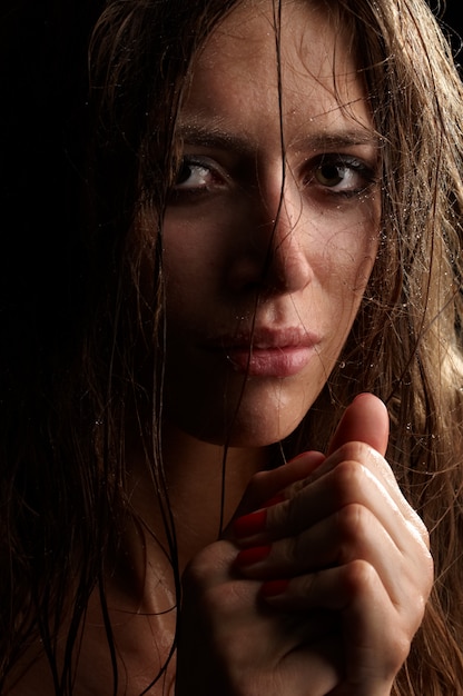 Beautiful long hair brunette woman portrait, wet face, studio shot