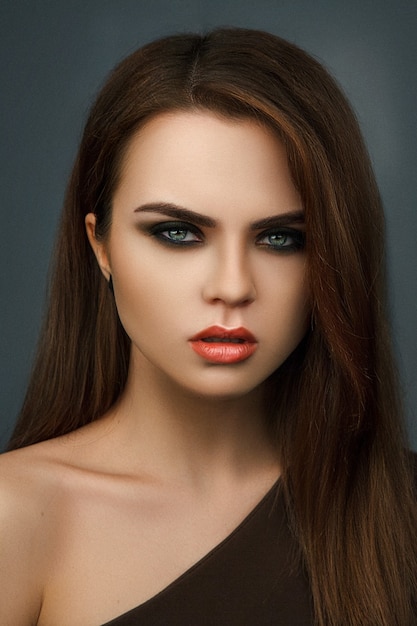 Beautiful long-hair model is posing with a creative makeup