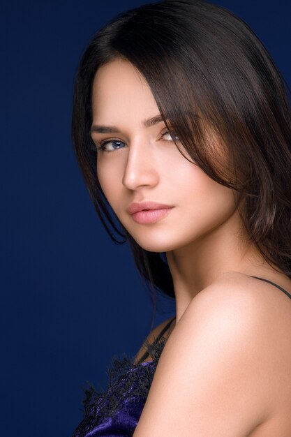 Beautiful long hair woman, blue dark background. Studio shot.