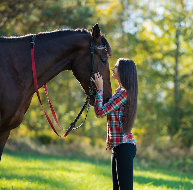 Beautiful long hair young woman with a horse outdoor