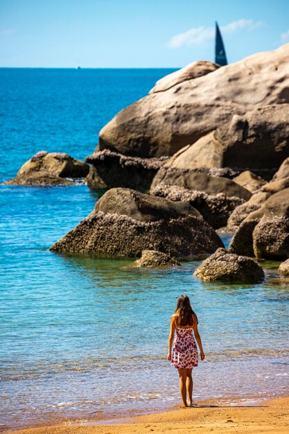 a beautiful long-haired girl in a dress relaxes on a paradise beach on magnetic island, australia