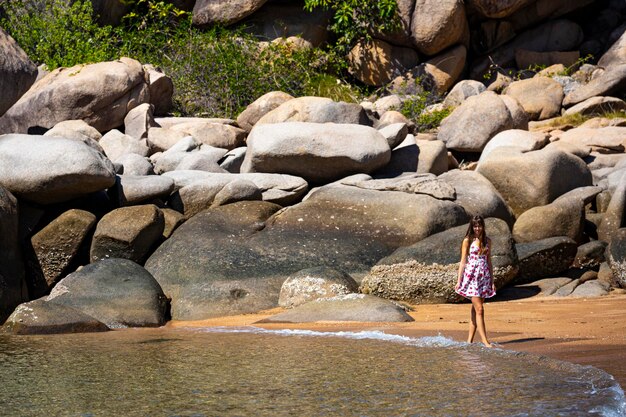 ドレスを着た美しい長髪の少女が、オーストラリアのマグネティック島の楽園のビーチでくつろぐ