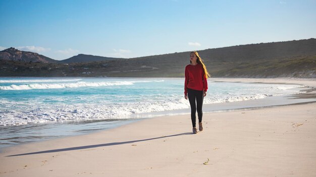 beautiful long-haired girl walks at sunset on the famous lucky bay beach in western australia