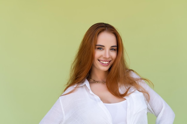 Beautiful long red hair woman in casual shirt on green background positive smiling laughing enjoying exited