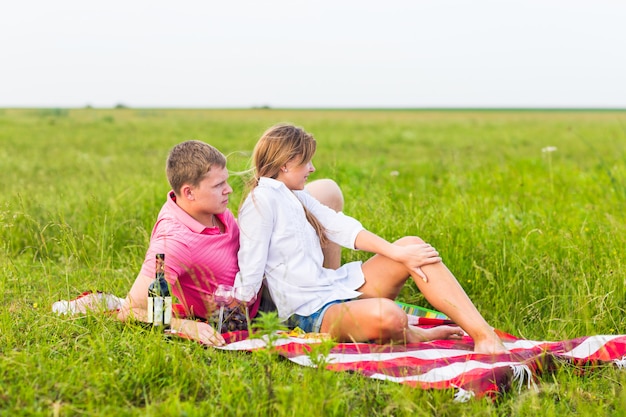 Beautiful love couple having romantic picnic outdoors on summer sunny day.