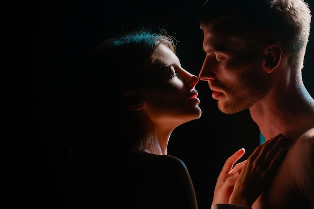 Beautiful loving couple posing on dark backgroung with night lights close up face of a beautiful you