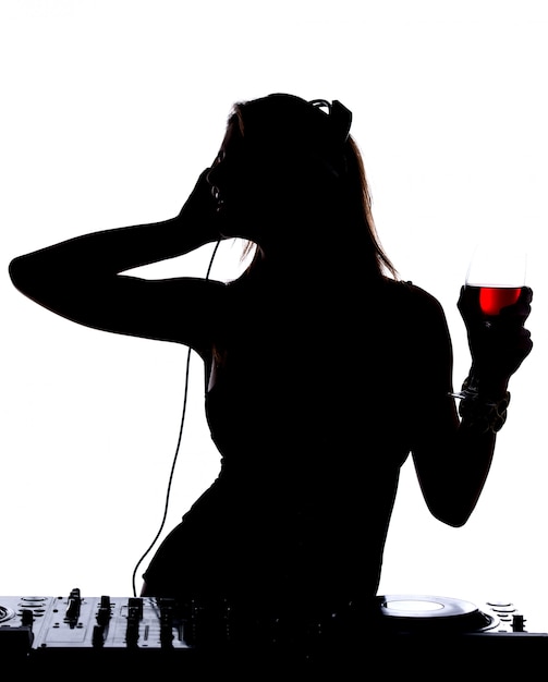 아름 다운 남성 DJ 실루엣과 그녀의 갑판 믹싱 사운드에 서있다.