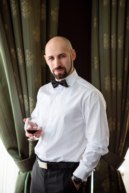 Beautiful male drinking Cognac in the restaurant.