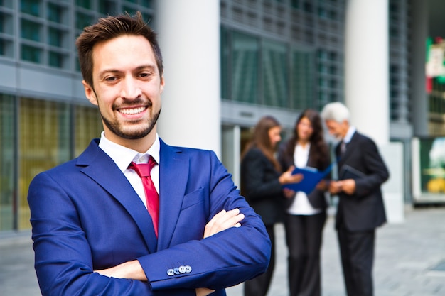 Beautiful man on the background of business people