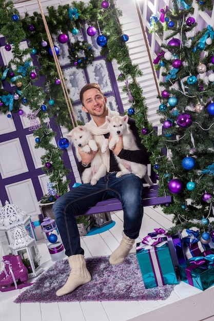 Beautiful man sitting on a terrace next to a Christmas decoration