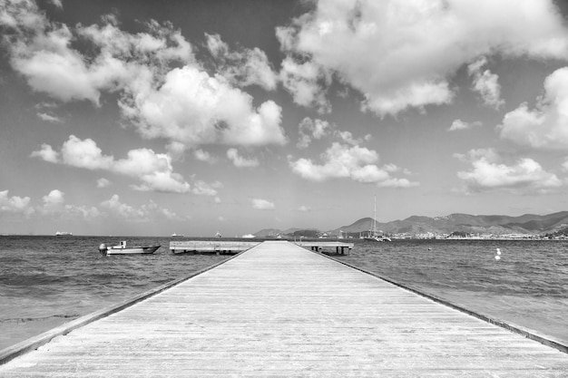 Beautiful marine dock with wooden pathway harbour and boats transport on water sunny summer outdoor on cloudy blue sky background