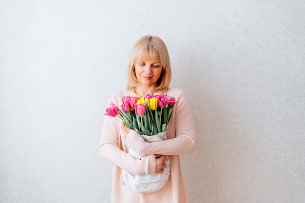 Beautiful mature woman holding tulips