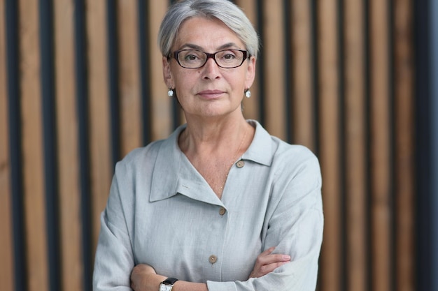 Beautiful mature woman in office arms crossed