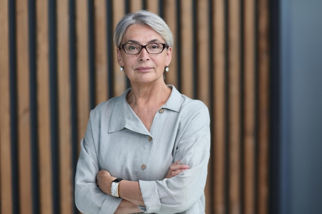 Beautiful mature woman in office arms crossed