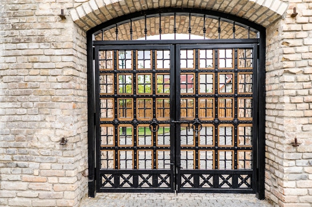 Beautiful medieval wooden gate with stone arch in old weathered building