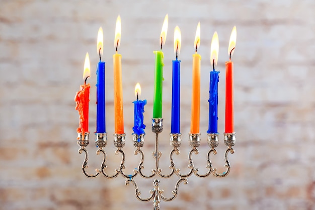 Beautiful menorah with burning candles on light blurred background hanukkah concept jewish holiday m...