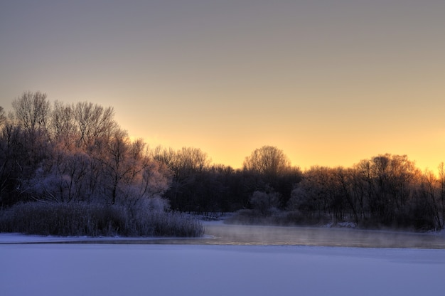 Beautiful mesmerizing views of the river melted at the beginning of spring with trees along the shore in a cool spring evening. Thaw concept and early spring days. Copyspace