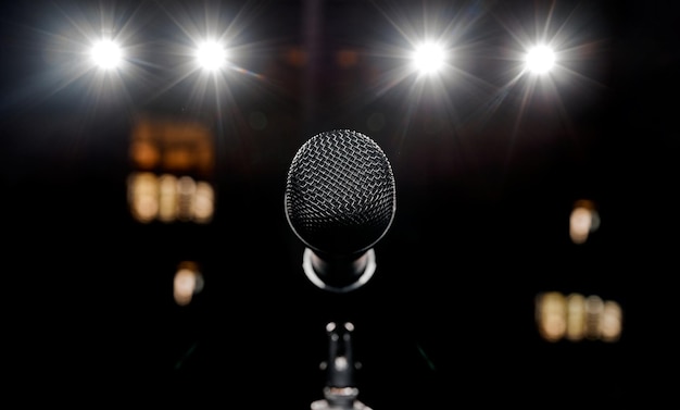 Фото Красивый микрофон на сцене и четыре красивых прожектора светятся на заднем плане. фото высокого качества