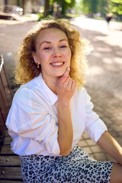 Прекрасная женщина средних лет в 70-х 80-х стиле одежды на скамейке на солнечной авеню
