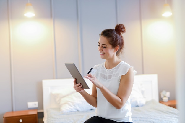 Beautiful middle age woman holding tablet in her hands and smiling.