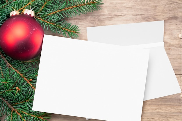 Фото Красивый макет белой открытки с рождественскими украшениями сбоку открытки