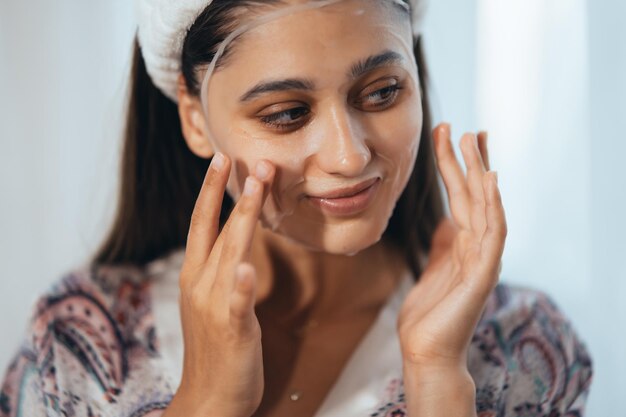 Beautiful model applying cosmetic cream treatment on her face