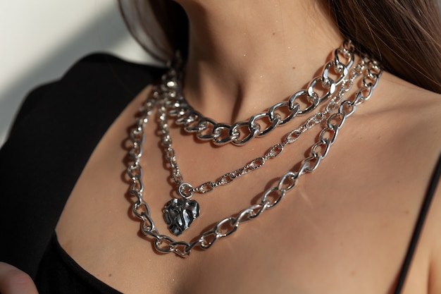 Beautiful model brunette in modern silver metal necklace many chains