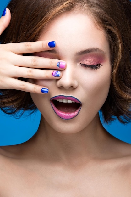 Photo beautiful model girl with bright makeup and colored nail polish beauty face short colorful nails