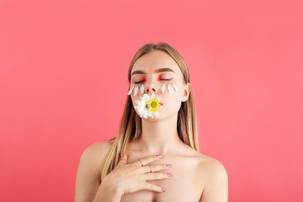 Beautiful model girl with flowers on pink background
