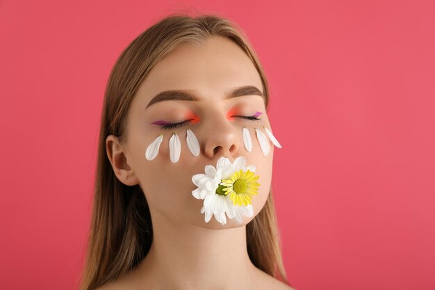 Beautiful model girl with flowers on pink background