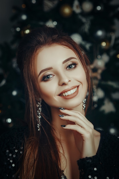 Beautiful model is posing in an interior room, decorated for Christmas