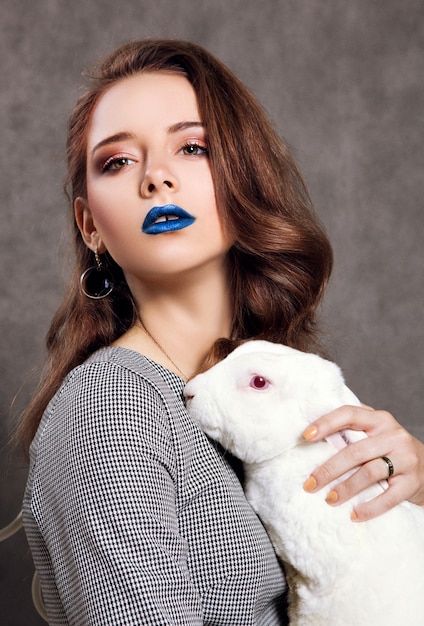 Beautiful model is posing with a white rabbit