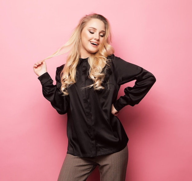 Beautiful model pose for a photo in trendy clothes over pink background