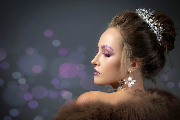 Beautiful model in profile with fashionable makeup in furs