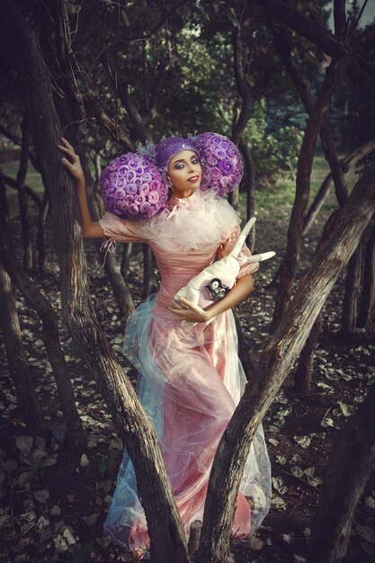 Photo beautiful model wearing pink dress posing with a purple wig