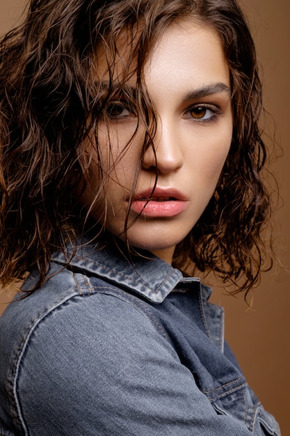 beautiful model with clean skin and curly hair in jeans denim jacket