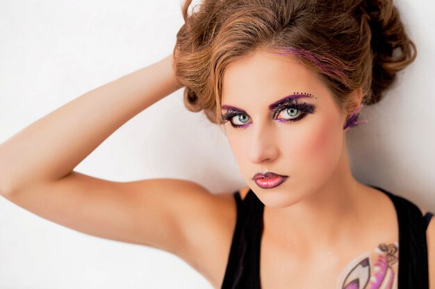 Beautiful model with fashion make-up and a picture on the body posing