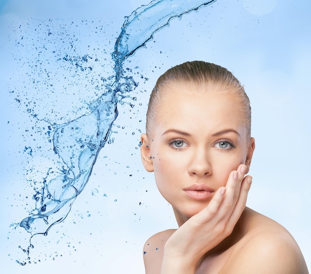 Beautiful model woman with splashes of water in her hands