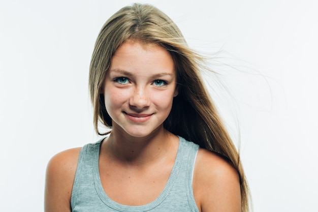 Bello ritratto di modello della ragazza della giovane donna con i capelli biondi lunghi delle lentiggini isolati su colpo bianco dello studio.