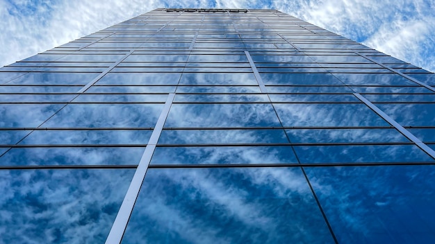 Красивая и современная высокая башня с облаками в финансовом районе. Замечательный бизнес-офис небоскреба в центре города в день красоты с голубым небом. Окна ориентир горизонта