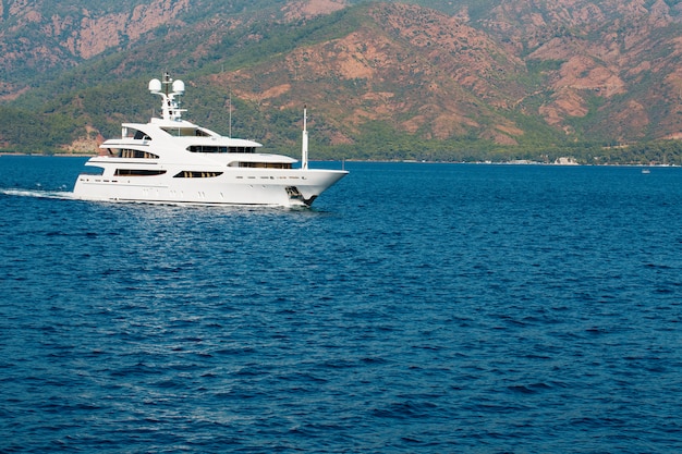 Beautiful modern white yacht with sail on the blue sea