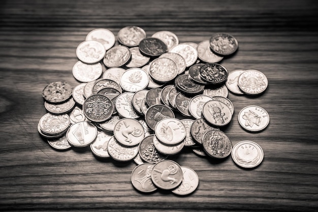 Photo a beautiful monochrome picture of coins on a wooden table