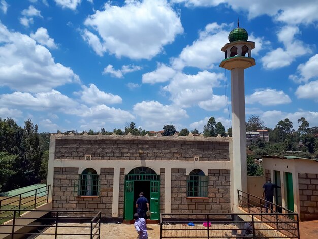 Photo a beautiful mosque in kiambu kenya among the trees and under beautiful clouds