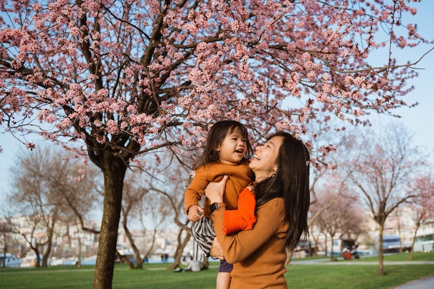 写真 桜まつりの期間中、美しい母と娘が公園で楽しむ