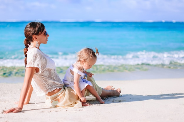 Belle madre e figlia sulla spiaggia godendo le vacanze estive.