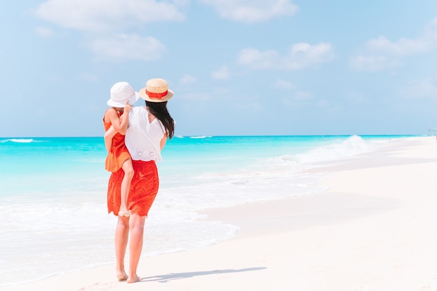 Beautiful mother and daughter at the beach enjoying summer vacation.