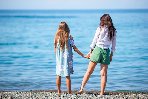 Beautiful mother and daughter at the beach enjoying summer vacation