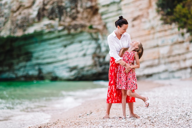 여름 휴가를 즐기고 해변에서 아름다운 어머니와 딸.